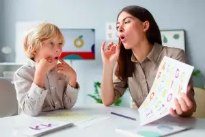 Fonoaudiólogo trabalhando com um garotinho loiro