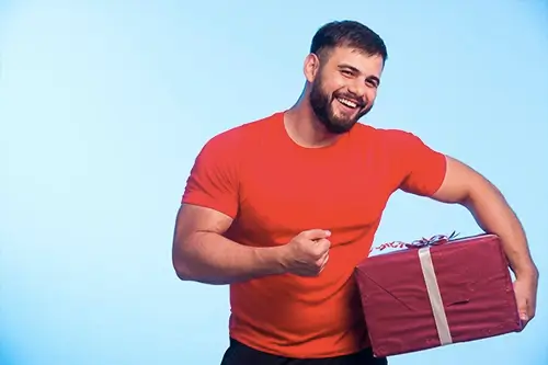 Homem forte segurando um presente
